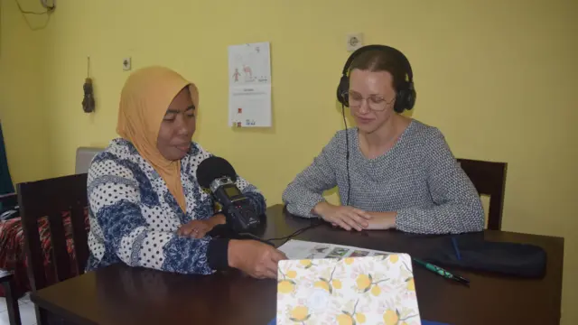 Emily Havens duduk bersama warga Kampung Bahari yang merupakan penutur asli bahasa Cia-Cia. Emily merekam warga menuturkan kosa kata dalam bahasa Cia-Cia.