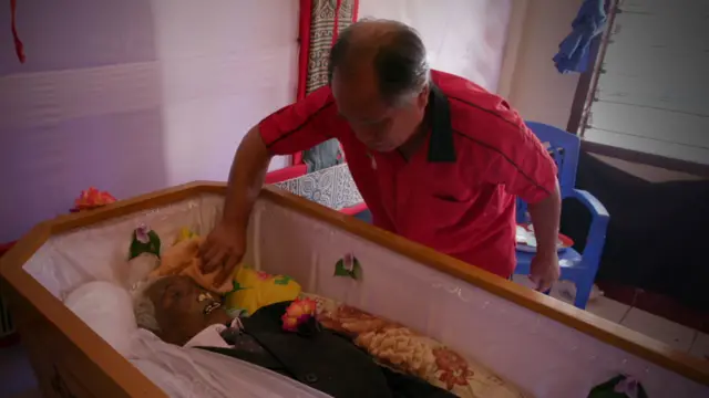 Hombre limpiando el rostro de un ser querido fallecido