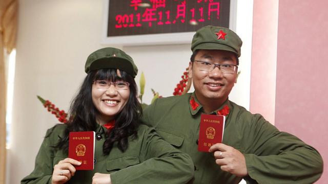 Couple in fancy dress shows their marriage certificates