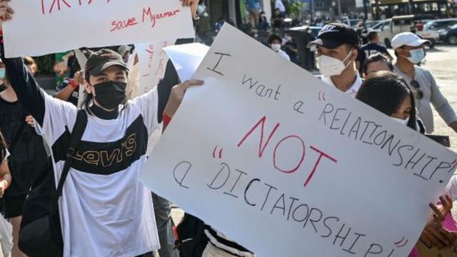 Protest sign reading "I want a relationship not a dictatorship"