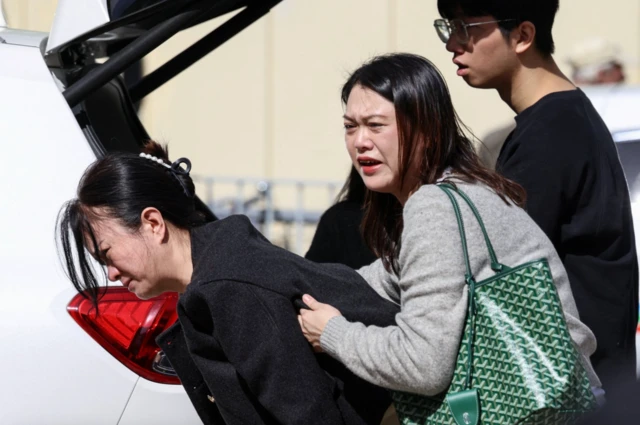  دو زن در هانگ‌کانگ در محلی‌آتش سوزی در حال گریه دیده می‌شوند