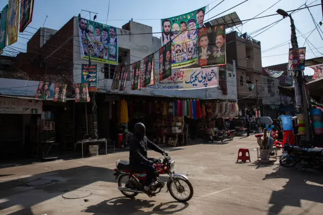 Campaign posters hang over a street ahead of Pakistan's national election in Lahore, Pakistan