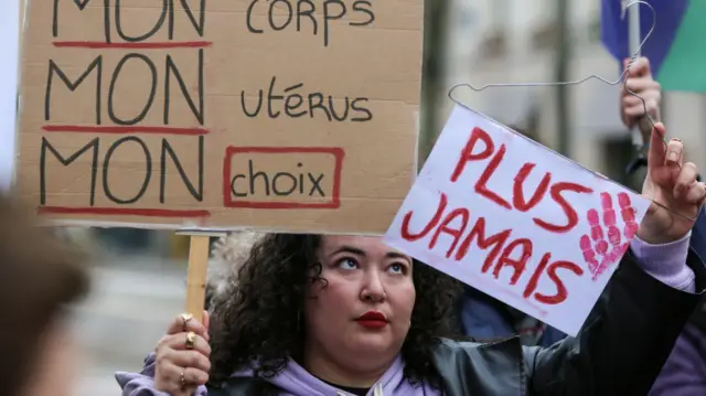 Manifestante segura cartazes que dizem “Meu corpo, meu útero, minha escolha” e “Nunca mais” durante protesto silenciosobetnacional código promocionalapoio à revisão constitucional