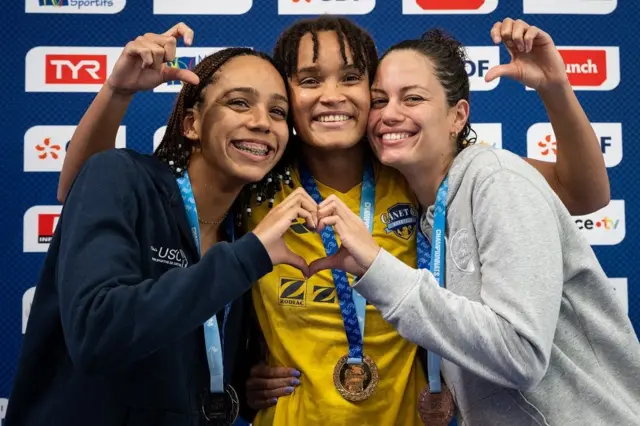 Atletas francesas abraçadas celebrando suas medalhas