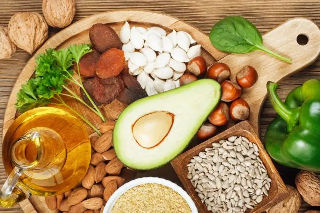 zeytinyağı, avokado, kuruyemiş dolu bir tahta tepsi
