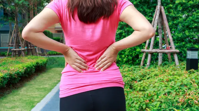 Mujer tomándose la parte baja de la espalda