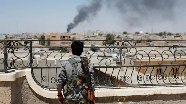 Rakka'da ABD uçaklarının vurduğu noktaları Suriye Demokratik Güçleri'nden bir militan izliyor.