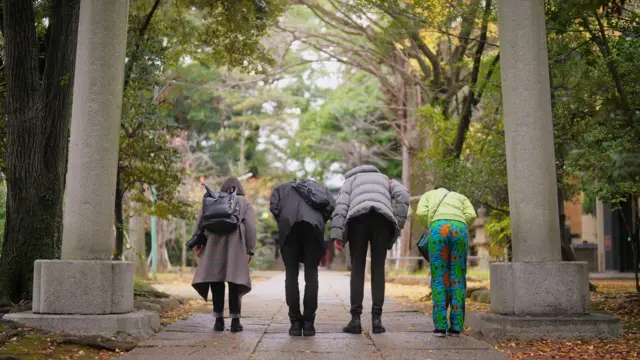 Um grupo de amigos de diferentes etnias está visitando um santuário durante sua viagem