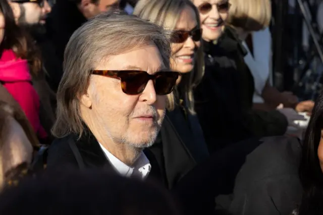 Paul McCartney sentandosite da betâniaum evento usando óculos escuros