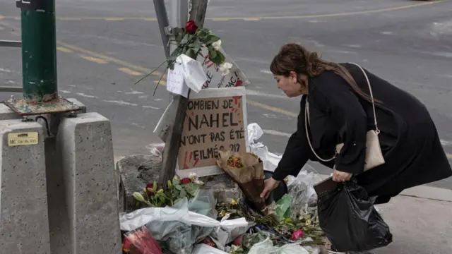 প্যারিসের নানতের শহরতলীর যে জায়গায় পুলিশের গুলিতে ১৭ বছরের তরুণ নাহেল মারা যায় সেখানে শনিবার ফুল দিচ্ছেন এক নারী 