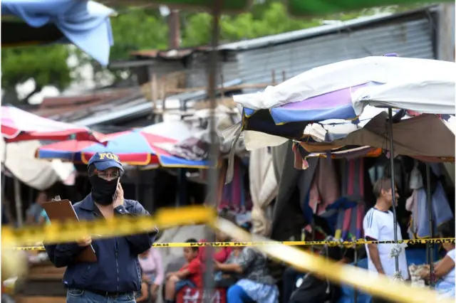 Miembro de la policía de investigaciones en San Salvador tras un homicidio el 15 de marzo de 2017.