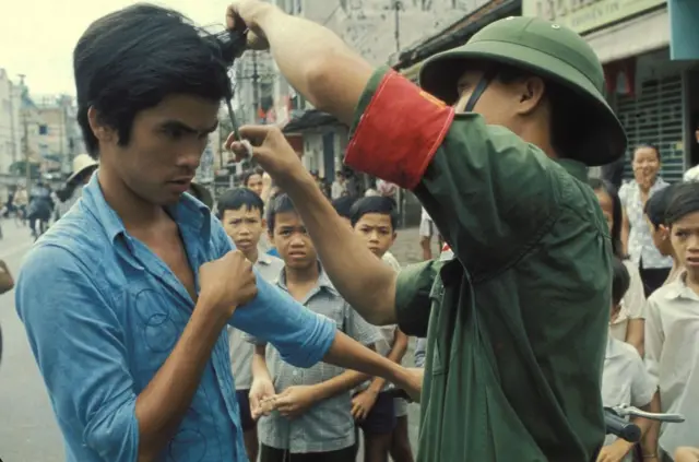 Một thanh niên bị bộ đội cắt tóc ngay giữa đường phố tại Sài Gòn.