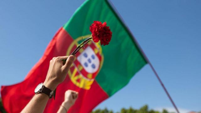 Bandera de Portugal con un clavel al fondo