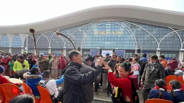 पोखरा अन्तर्राष्ट्रिय विमानस्थलको उद्घाटनका बेला पन्चेबाजा बजाउँदै एउटा टोली र उक्त कार्यक्रममा उपस्थित अरू मानिसहरू 