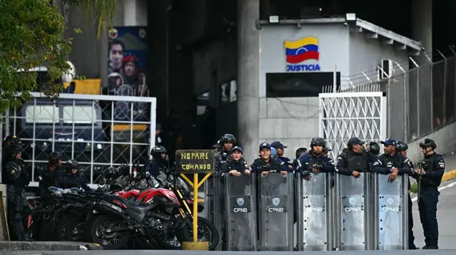 Полицейские со щитами стоят у въезда на территорию тюрьмы