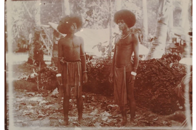 Dua pria di Pulau Biak difoto antara 1910 dan 1930. Mereka terlihat mengenakan mengenakan samfar (gelang manset) di lengan.