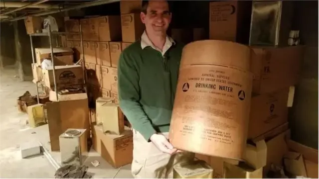 શેલ્ટરમાંનું વોટર કન્ટેઈનર દેખાડી રહેલા બ્લાઝિક