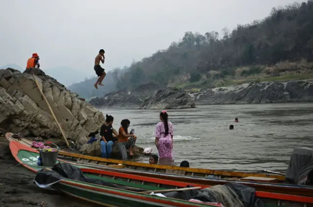 THAILAND-MYANMAR-POLITICS-MILITARY-REFUGEES
Villagers bathe on the Thai side of the Salween River in Mae Hong Son province on March 31, 2021, across from where Myanmar refugees earlier attempted to cross the Thai-Myanmar border after military bombings in Karen state. (Photo by Lillian SUWANRUMPHA / AFP) (Photo by LILLIAN SUWANRUMPHA/AFP via Getty Images)