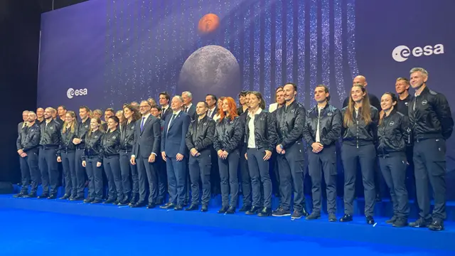 Homens e mulheres enfileiradossimulador da lotofácilpalco, posando para foto