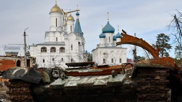 Destroyed Russian tank in front of orthodox temple in the liberated town of Sviatohirsk