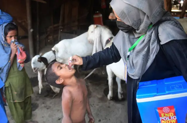 ကရာချီက ကာကွယ်ဆေးတိုက်ကျွေးရင်းကမ်ပိန်းကာလအတွင်း ကျန်းမာရေးဝန်ထမ်းတဦးက ကလေးငယ်တဦးကို ပိုလီယိုအစက်ချကာကွယ်ဆေးတိုက်ကျွေးစဉ်