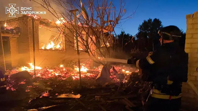رجل إطفاء يعمل على إخماد حريق في موقع في زابوريجيا تعرض لضربة روسية ليلاً
