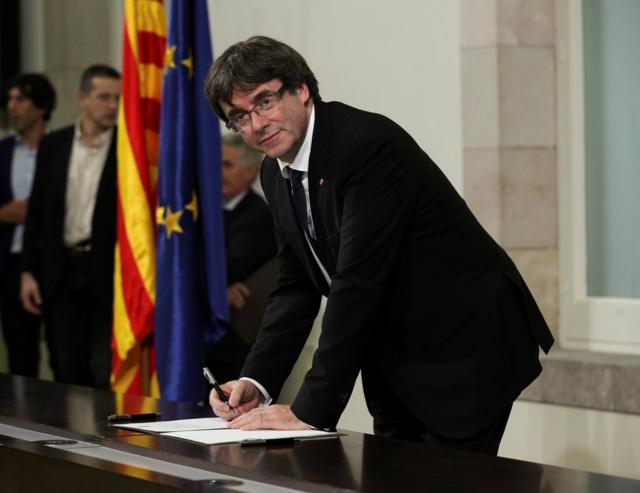 Catalan President Carles Puigdemont signs a declaration of independence at the Catalan regional parliament in Barcelona, Spain, October 10, 2017. REUTERS/Albert Gea TPX IMAGES OF THE DAY