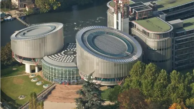 Fransa'nın Strazburg kentindeki AİHM binası tepeden görünüyor, iki dairesel cam binanın ortasında yine dairesel bir başka yapı var. 