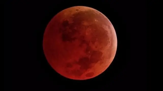 পূর্ণগ্রাস চন্দ্রগ্রহণের সময় পৃথিবীর বাযুমণ্ডলের মধ্যে দিয়ে সূর্যরশ্মি প্রবাহিত হয়ে যখন আসে তখন চাঁদের রং হয়ে ওঠে কমলা