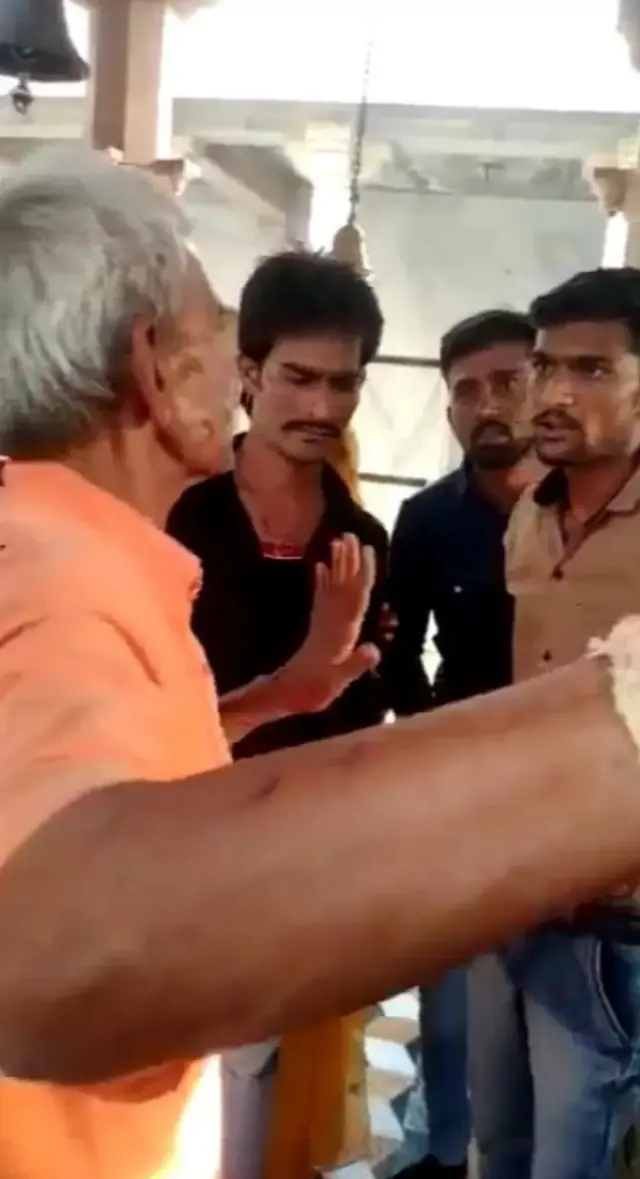 గుడికి వచ్చిన వారితో వాదిస్తున్న పూజారి