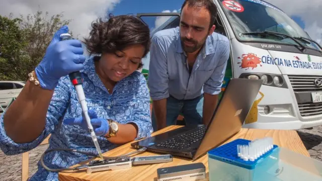 Médicos analizando virus al aire libre.