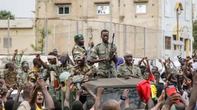Des membres armés des FAMA (Forces Armées Maliennes) sont célébrés par la population alors qu'ils défilent sur la place de l'Indépendance à Bamako le 18 août 2020.
