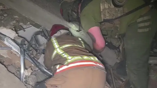 Screengrab of footage that shows rescuers in Ukraine digging through rubble