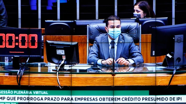 Foto do telão da câmara mostra deputado Marcos Pereira sentado à mesa, com máscara