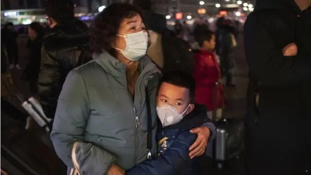 Mãe e filho chineses com máscara