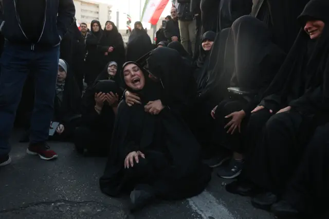 Dve žene, obučene u crno, koje plaču