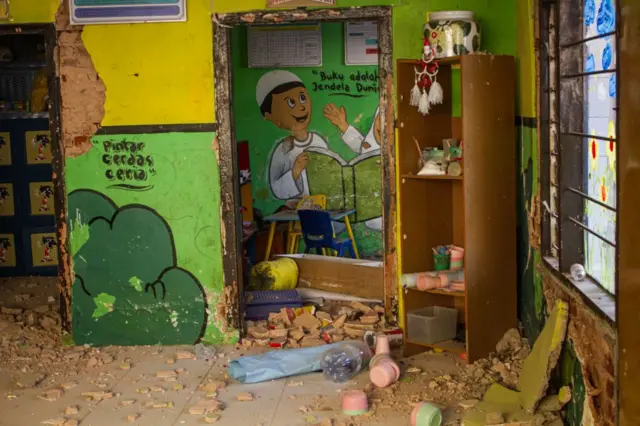 Dinding sekolah taman kanak-kanak runtuh setelah gempa berkekuatan 5,0 skala Richter melanda Jawa Barat, Indonesia, pada 18 September 2024. Setidaknya 700 rumah rusak, 82 orang terluka, dan tidak ada korban jiwa yang dilaporkan, menurut Badan Penanggulangan Bencana Daerah Jawa Barat.