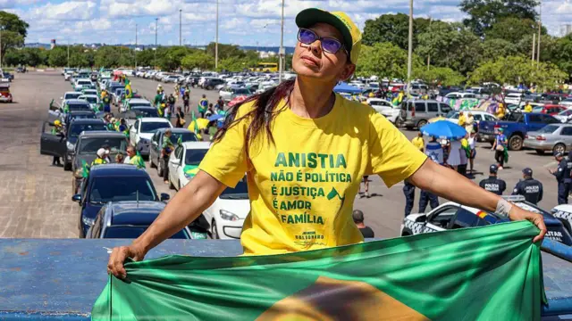 Uma manifestante de camiseta amarela co os dizeres "Anistia / não é política / é justiça / é amor / é família".