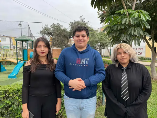 Consuelo, Álvaro y Cielo están parados mirando a la cámara. Posan en lo que parece ser un parque en Lima