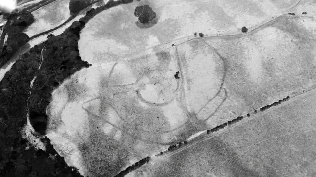 Dramatic parchmarks of First World War practice trenches beneath a golf course at Deganwy, Conwy (17 July 2026). Black and white image of golf course with markings on it.