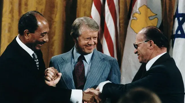 Shugaban masar Anwar Sadat, da shugaban Amurka Jimmy Carter da kuma Firaministan Israila Menachem Begin suna gaisawa a shekarar 1978
