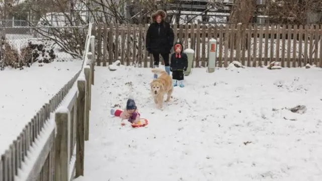 शावनी भागामध्ये बर्फात खेळणारे अॅलिसन लुसी यांचे कुटुंब.