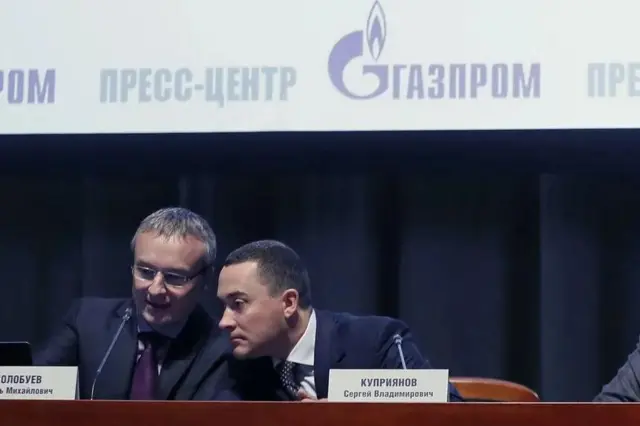 Два мужчины за столом с табличками, на которых написаны их имена и фамилии