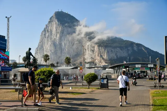 Vista urbana con un primer plano del Peñón de Gibraltar. Edificios y vehículos en primer plano.