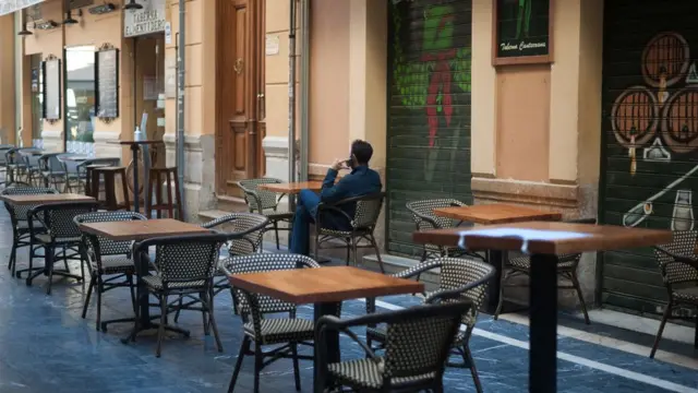Hombre sentado en una terraza vacía