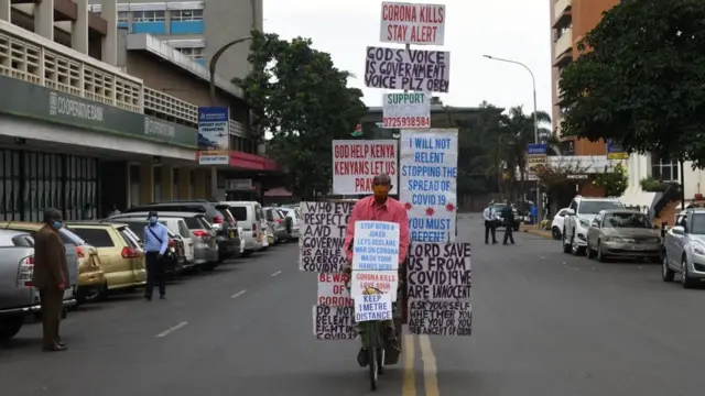 케냐 나이로비에서 한 남성이 자전거에 코로나19의 위험성을 알리는 문구들을 붙이며 지나가고 있다