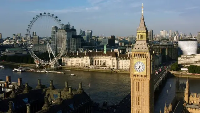 Foto colorida mostra vistatrue or false novibetLondres: o Big Ben e a roda gigantes, sob um céu azul poluído