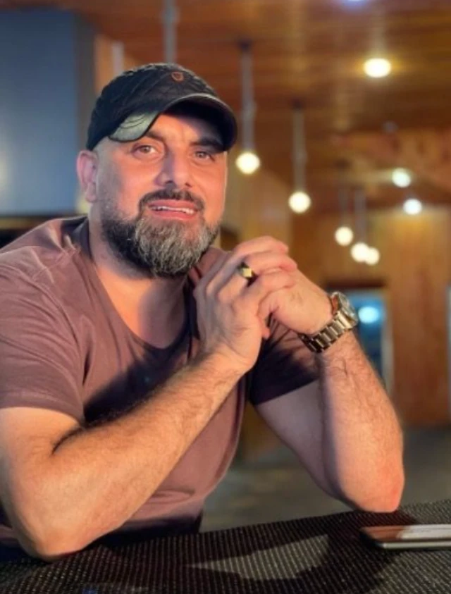Samer Ebu Dakka kollarını masaya dayamış oturuyor