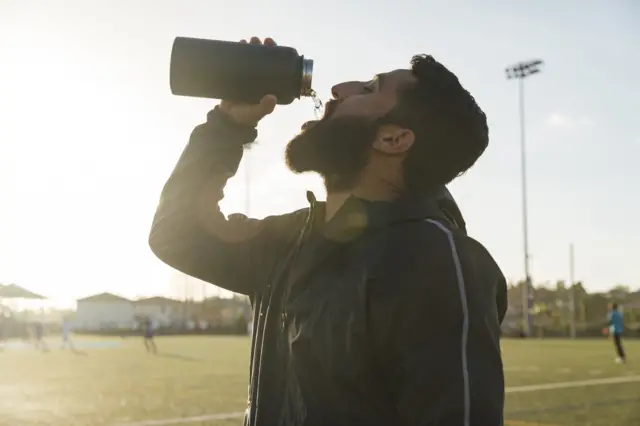 A male athlete drinking water