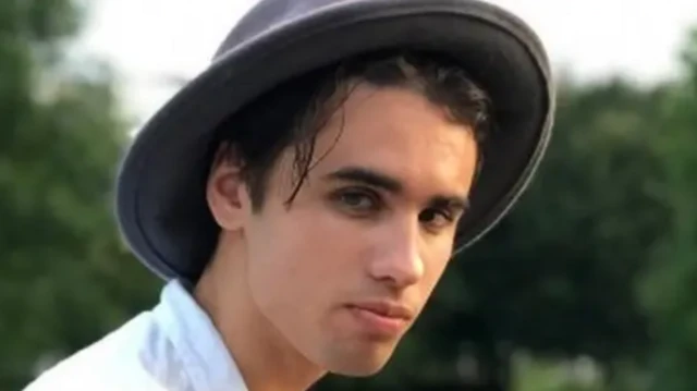 Политзаключенный Егор Дудников, отбывающий в Беларуси 11-летний срок. Это его фотография из "ВКонтакте". Он крупным планом вполоборота смотрит в камеру, на нем серая шляпа и белая рубашка